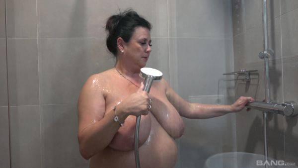 Busty nude mature showers and masturbates in a kinky combo on breastful.com