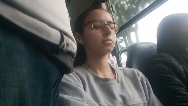 Young Brazilian woman with glasses rests on a bus while being subtly observed - Brazil on breastful.com