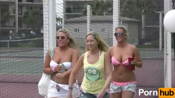 Bikini-clad women tease and mingle at a lively beachside party on breastful.com