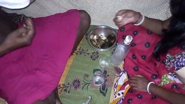 Dark-skinned woman in traditional scarf shares liquor before intimacy on floral blanket on breastful.com