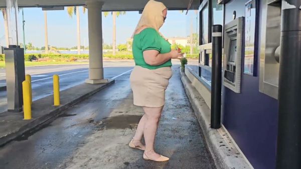 Woman in green and hijab meets stranger by silver SUV in parking lot on breastful.com