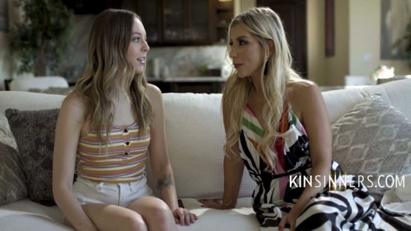 Blonde and brunette lovers heat up on a white couch in a modern living room on breastful.com