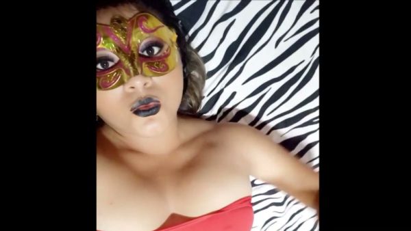 Brunette MILF stuns in red top and ornate mask on zebra print backdrop on breastful.com