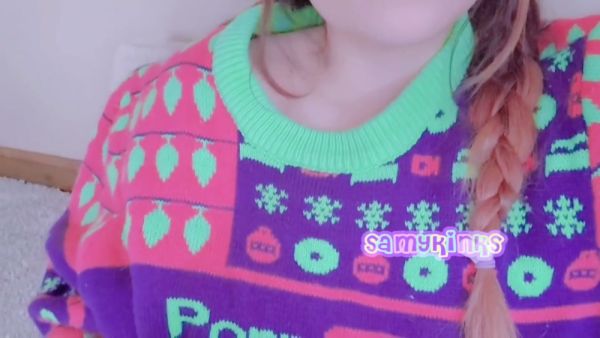 Young woman in festive sweater explores herself on the carpet on breastful.com