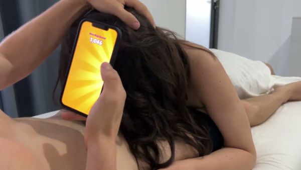 Curvy brunette gives her boyfriend a blowjob while he plays games in bed on breastful.com