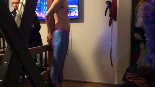 Feminized man bound to bed frame by dominant woman in intimate bedroom session on breastful.com