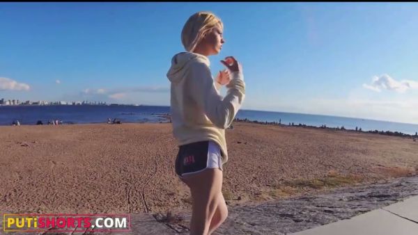 Blonde in athletic shorts spreads for a tattooed man on a white leather couch on breastful.com