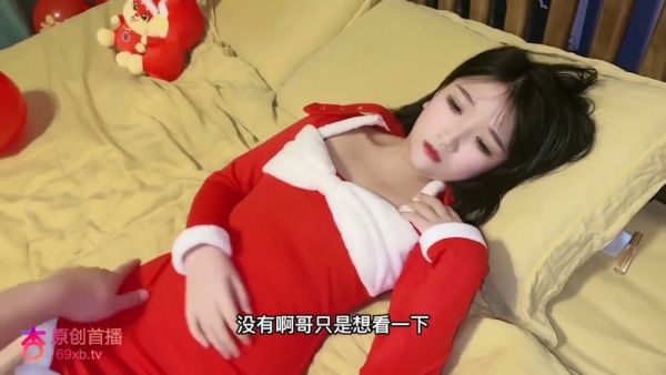 Young Asian woman in Santa dress explores intimacy in festive setting on breastful.com