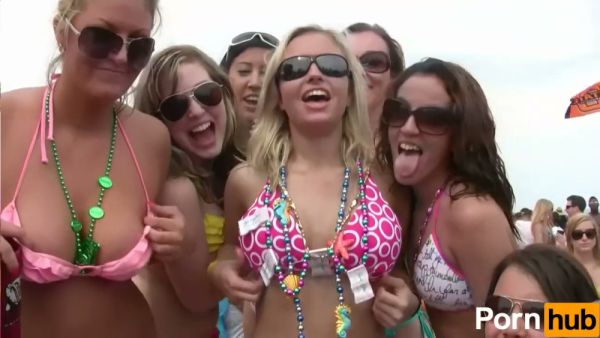 Blonde lesbians kiss and embrace at a crowded beach party in matching bikinis on breastful.com