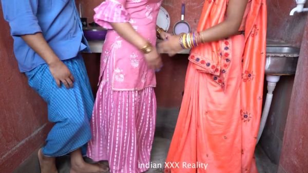Indian couple shares intimate kitchen moment with a guest in traditional attire - India on breastful.com