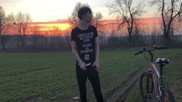 Young man with curly brown hair jerks off outdoors on a red bicycle during sunset on breastful.com