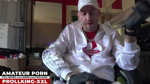 Man in cap and gloves tests a transparent device on his erect cock in a red-walled room - Germany on breastful.com